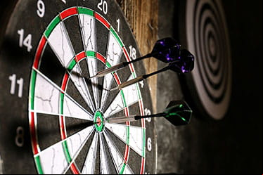 Three darts stick in a dartboard.