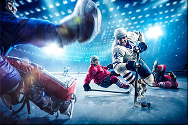An ice hockey player dekes out two defenders and the goalie on his way to the net.