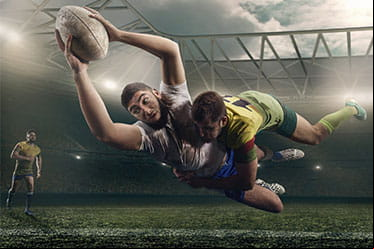 A rugby defender tackles the opposing ball carrier.