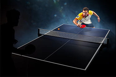 A male table tennis player prepares to return a serve to his opponent.
